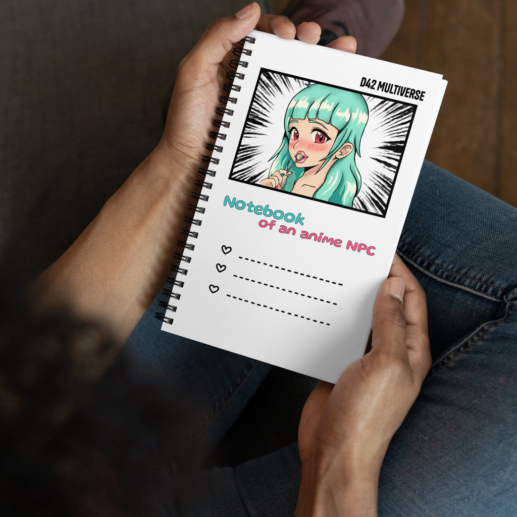 Weißes D42 Spiralnotizbuch mit Manga-inspirierter Illustration eines türkishaarigen Anime-Charakters und dem Schriftzug „Notebook of an anime NPC“ in der Hand gehalten