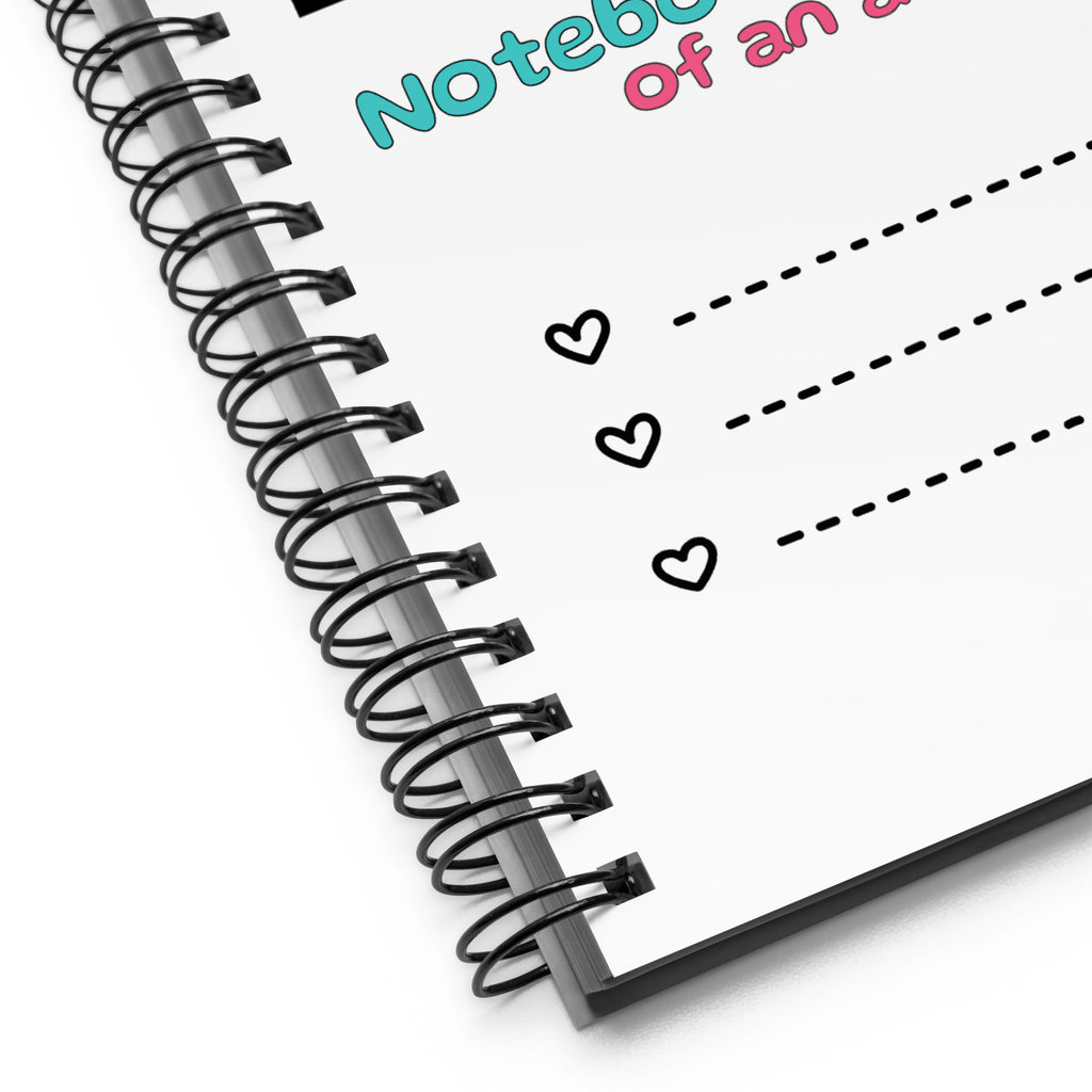 Weißes D42 Spiralnotizbuch mit Manga-inspirierter Illustration eines türkishaarigen Anime-Charakters und dem Schriftzug „Notebook of an anime NPC“ Nahaufnahme der Bindung

